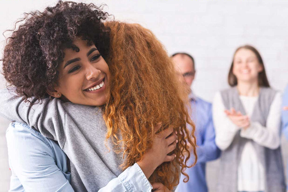 women hugging during therapy session